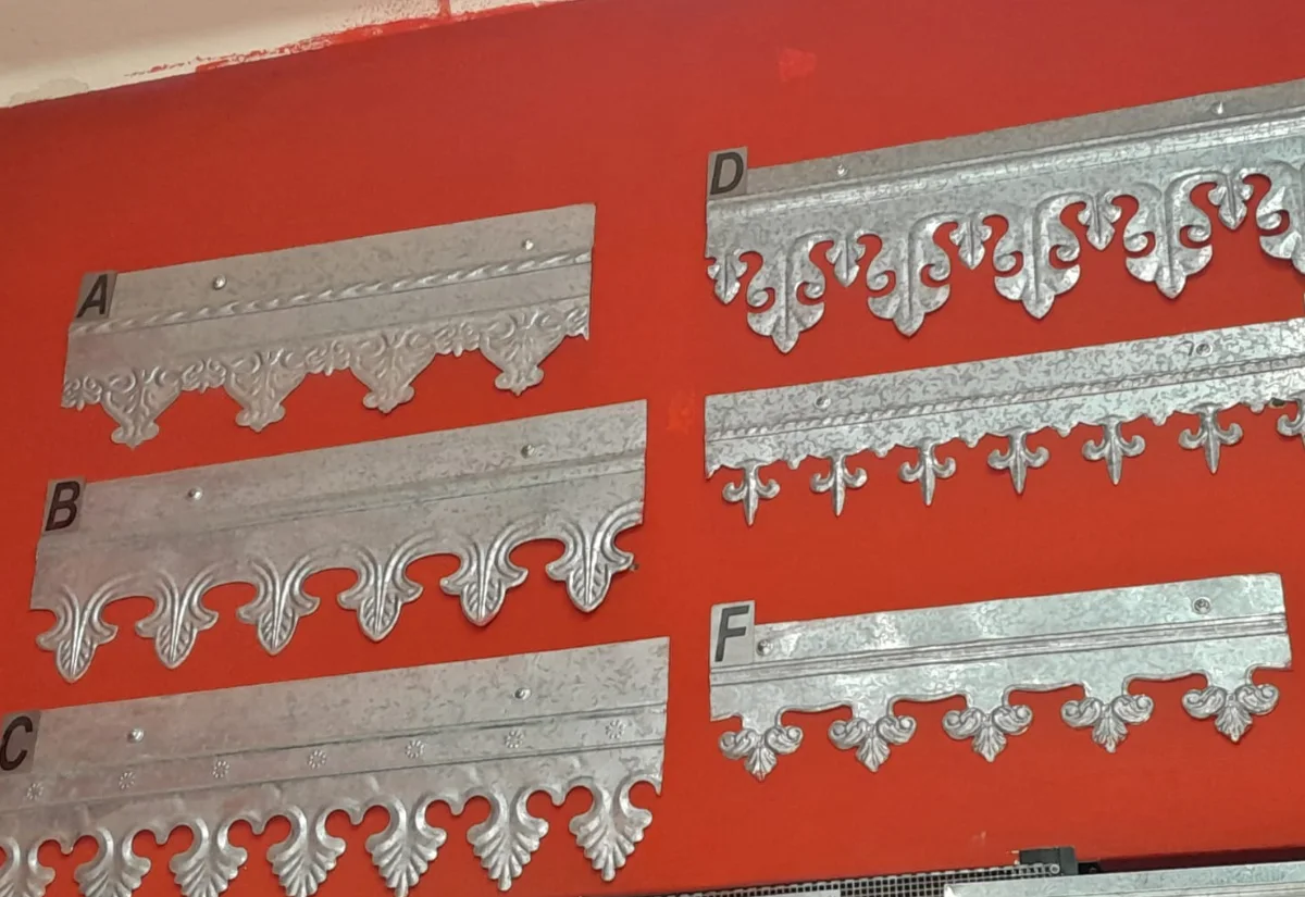 Seis modelos de cenefas de chapa galvanizada estampadas con relieve, en la pared del local de Rapimetal en Villa Urquiza