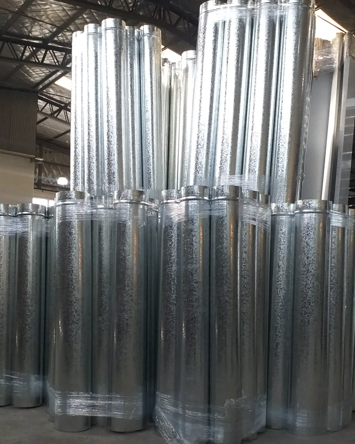 Caños redondos de chapa galvanizada apilados en la planta