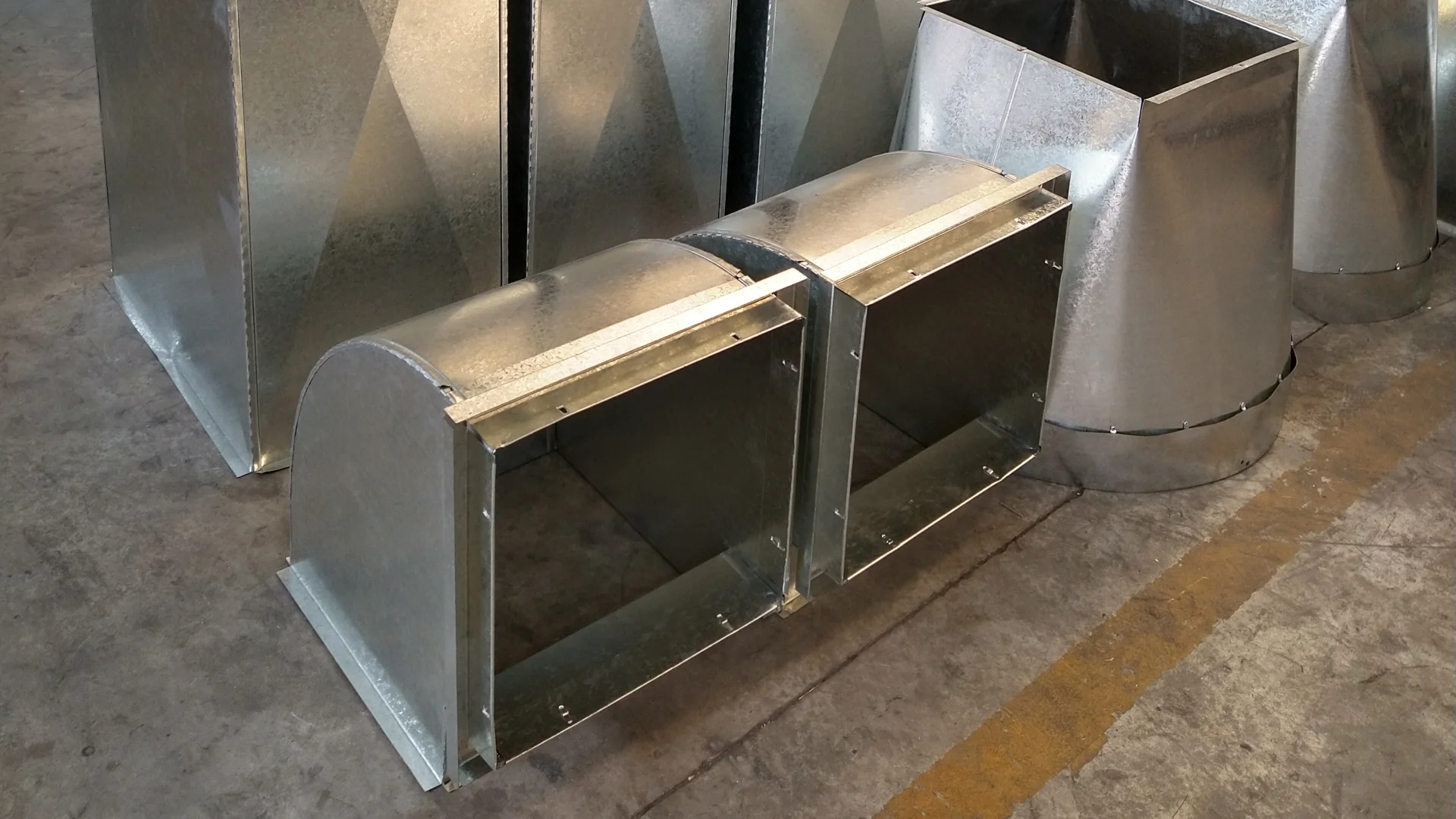 Conductos rectangulares de chapa galvanizada con punta diamante recién fabricados, en el taller de Rapimetal