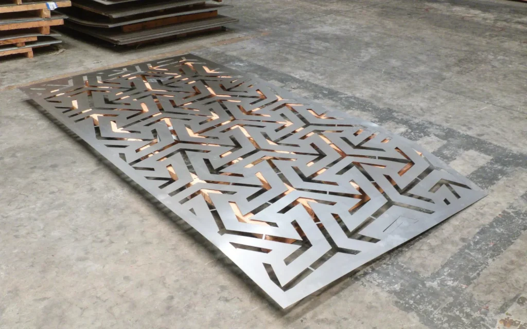 Panel decorativo de chapa Flechas sin pintar, apoyado en el piso (imagen ilustrativa)