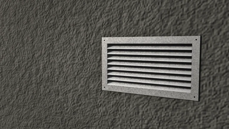 Rejilla de ventilación de chapa galvanizada colocada en una pared revocada